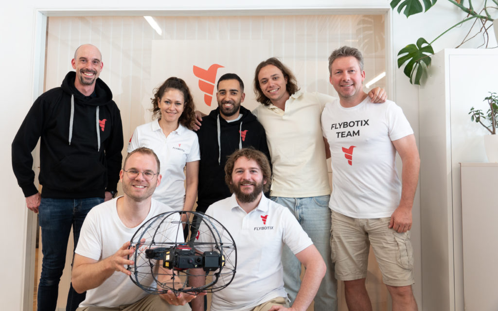 Flybotix employees in office holding ASIO X drone